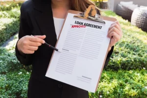 Midsection of woman holding loan agreement while standing against plants
