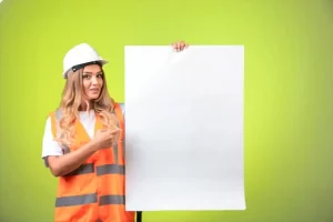 Female engineer in white helmet and gear showing the construction plan and explaining it.