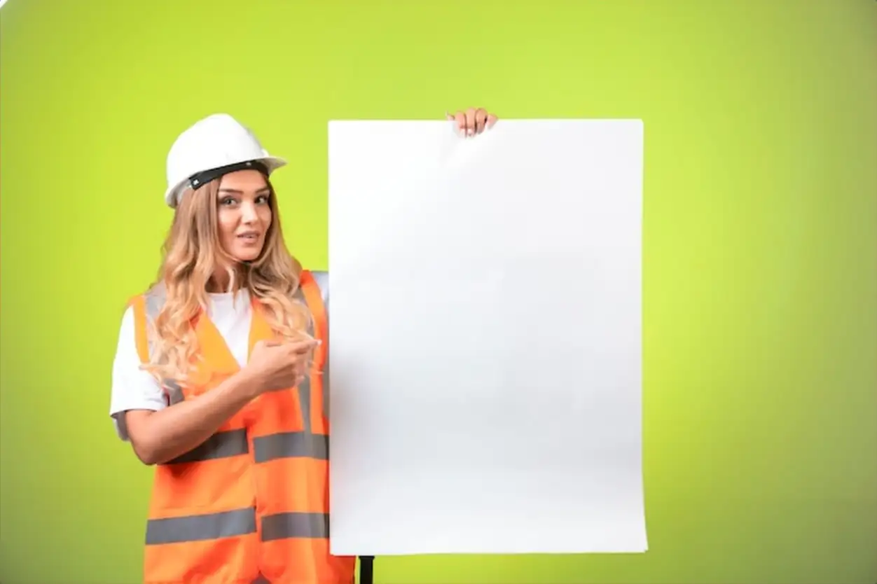 Female engineer in white helmet and gear showing the construction plan and explaining it.